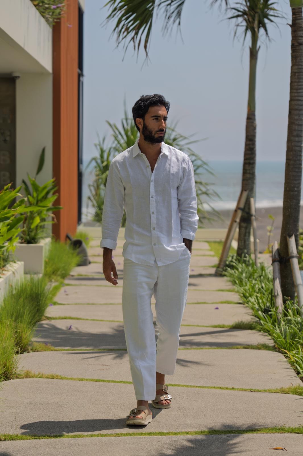 Suroesh Jazayeri walking along a garden path towards the sea.